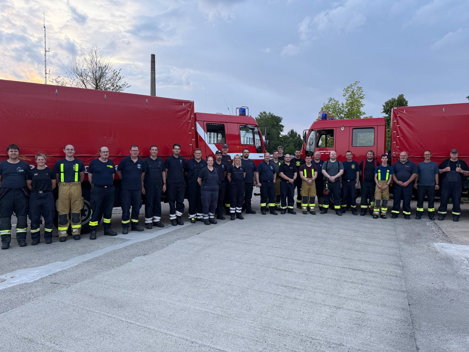 Gruppenfoto des ABC-Zugs vor den Fahrzeugen des Landkreises Peine